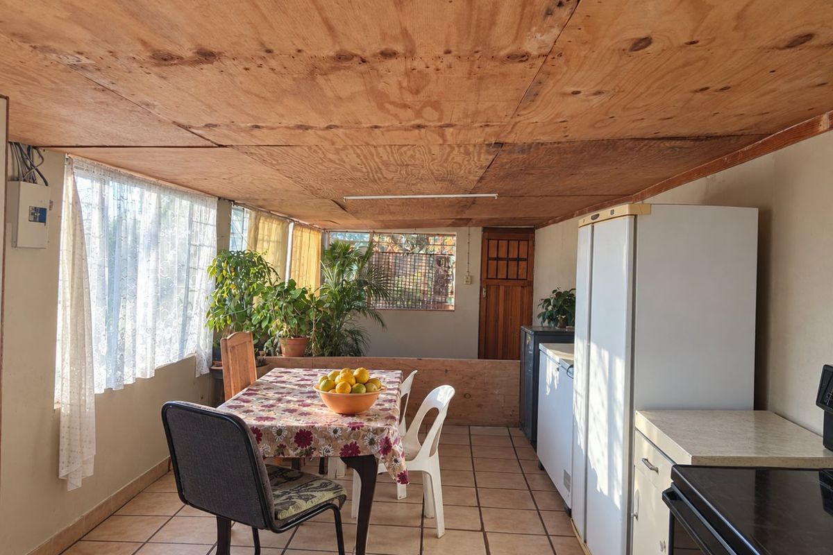 Open plan living and dining area featuring ceramic tiled flooring and a plywood ceiling, offering a functional space with potential for modernization.