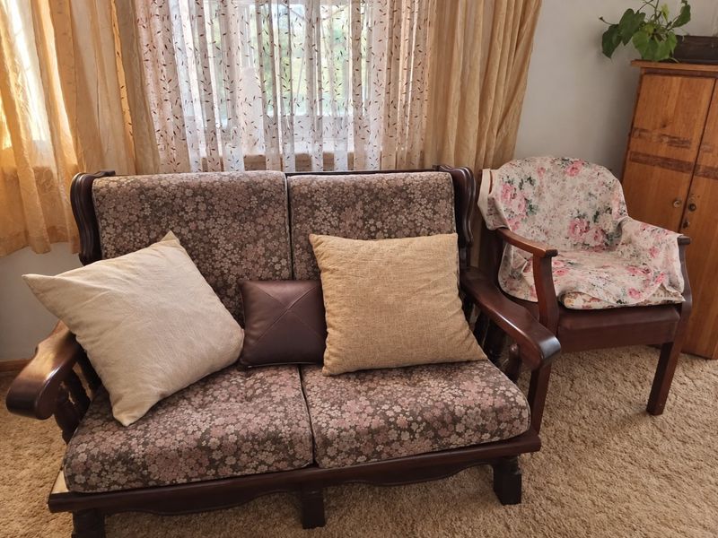 A living room area featuring window treatments and carpeted flooring, providing a functional space for relaxation.