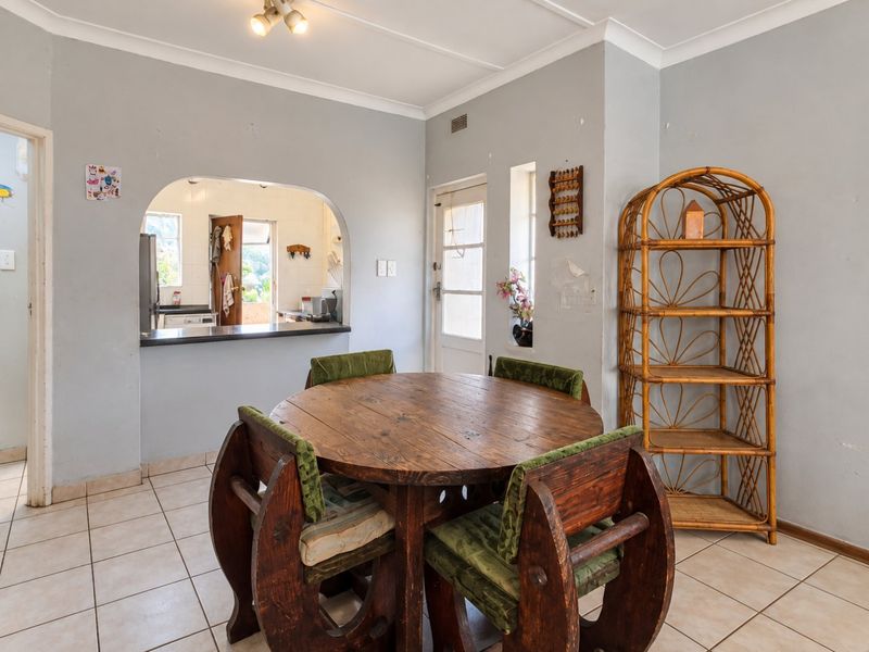Dining area featuring tiled flooring, a coved ceiling, and an arched opening providing a view into the adjacent kitchen space.