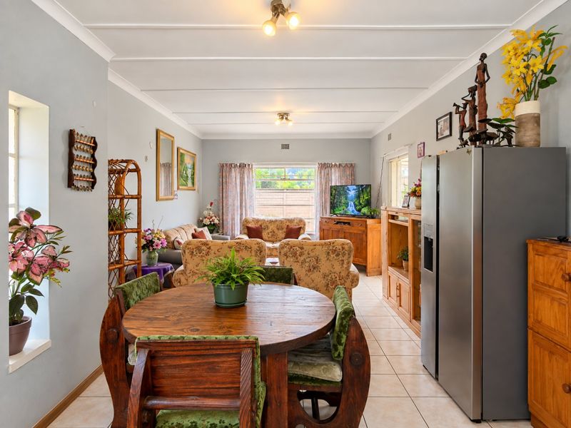 An open-plan living and dining area featuring tiled flooring and neutral wall tones, offering a functional layout for daily living and entertaining.