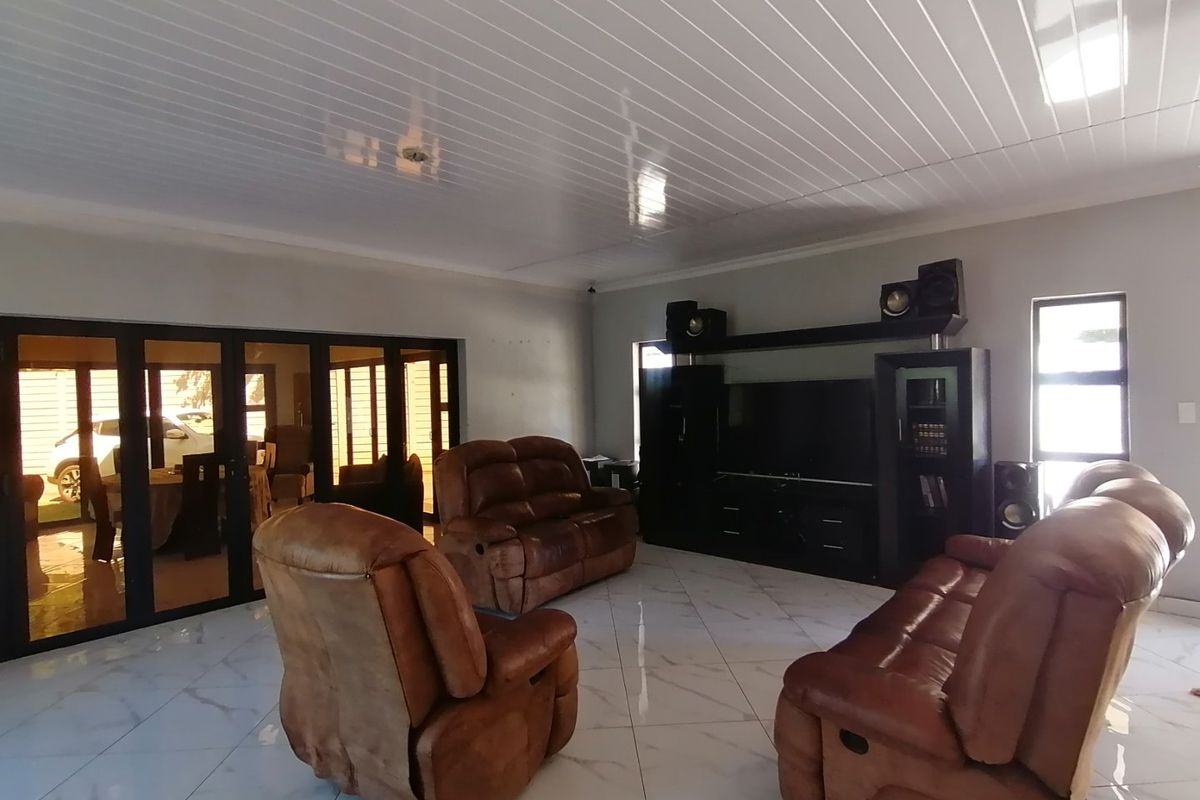 Spacious living room featuring large format tiled flooring, a modern PVC ceiling, and bi-fold doors providing access to the outdoor area.