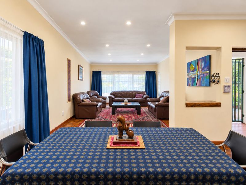 Spacious open-plan living and dining area featuring recessed downlights, coving, and warm timber flooring, creating a comfortable and inviting atmosphere.