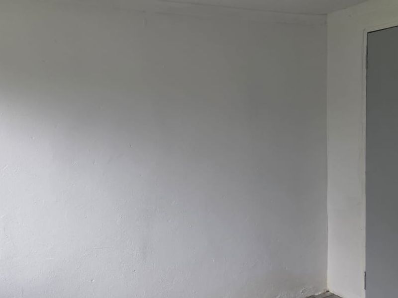 An empty bedroom featuring a built-in cupboard with a plain white wall finish.