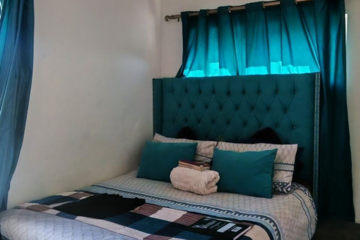 A bedroom featuring tiled flooring and a ceiling light fixture, providing a functional space for rest.