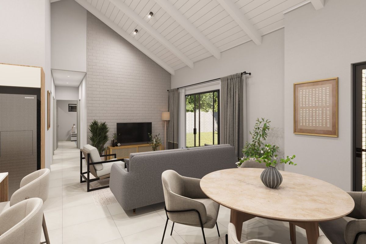 Spacious open-plan living and dining area featuring a high vaulted ceiling with exposed beams, a brick feature wall, and large sliding doors to the garden.