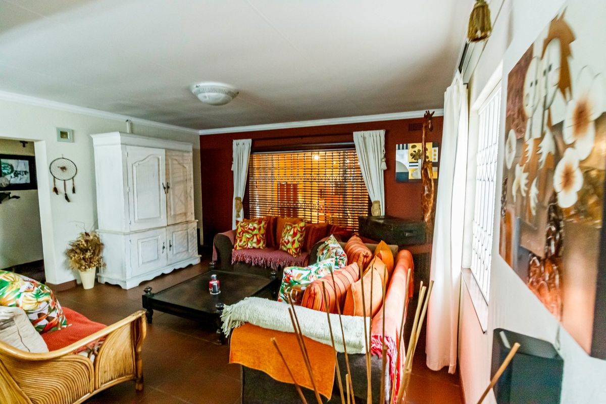 A living room featuring tiled flooring, coving, and window blinds, providing a functional space with potential for modern updates.