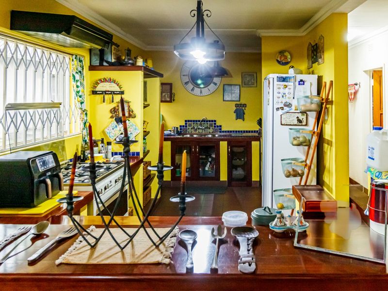 A functional kitchen featuring built-in cabinetry, a gas hob with extractor fan, and a tiled splashback, offering a traditional layout with ample counter space.