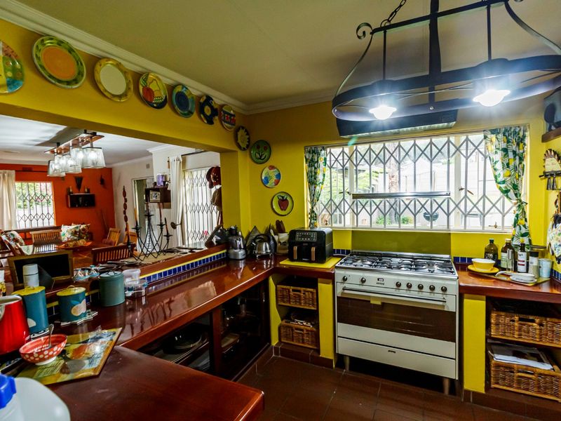 A functional kitchen featuring a gas stove, wooden countertops, and built-in cabinetry, with an open-plan layout connecting to the adjacent living area.