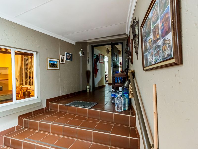 An interior entry area featuring a tiled staircase with a handrail, leading into the main living spaces of the home.