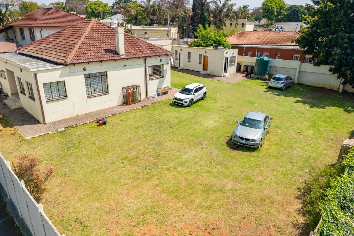 Aerial view of the property showing the rear garden, main house structure with tiled roof, and secondary outbuilding with water tank.