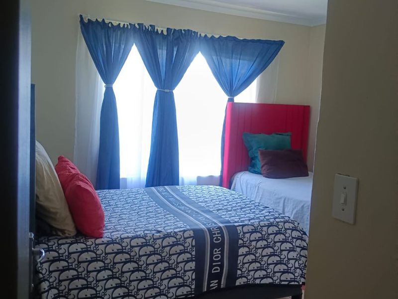 A bedroom featuring tiled flooring and a coved ceiling, viewed from the doorway.