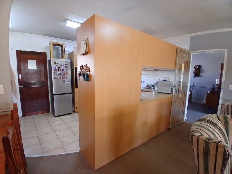 Open plan living area featuring a central partition wall separating the kitchen space from the main living area with mixed flooring finishes.