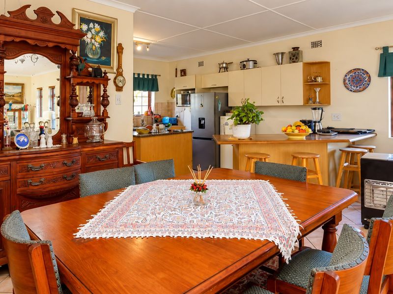 Open-plan dining and kitchen area featuring tiled flooring, built-in cabinetry, and a functional kitchen island layout.