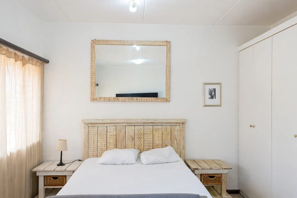 A bedroom featuring a built-in wardrobe and neutral finishes, providing a functional space with natural light from the window.