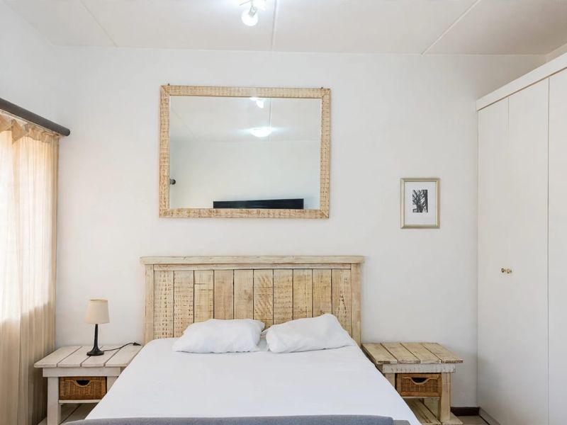 A bedroom featuring a built-in wardrobe and neutral finishes, providing a functional space with natural light from the window.