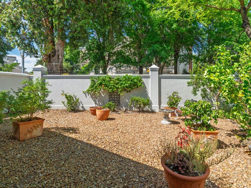A low-maintenance garden area featuring gravel landscaping, enclosed by a solid perimeter wall with integrated electric fencing for added security.