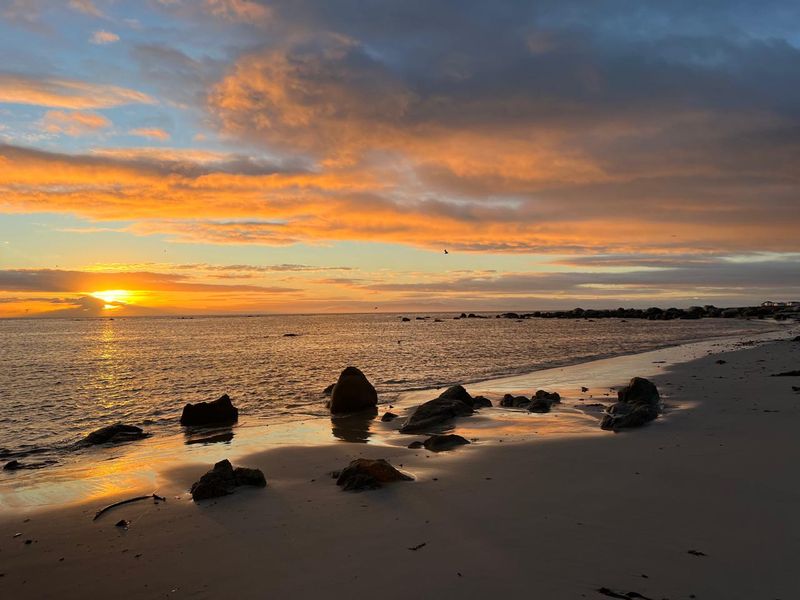 A scenic sunset view over the ocean and beach, highlighting the natural coastal landscape surrounding the property.