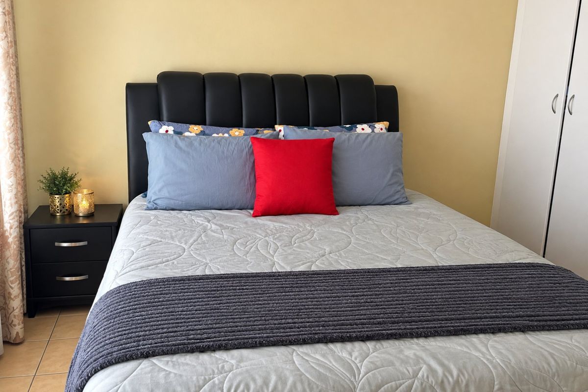 A bedroom featuring tiled flooring and a built-in wardrobe with neutral wall finishes.