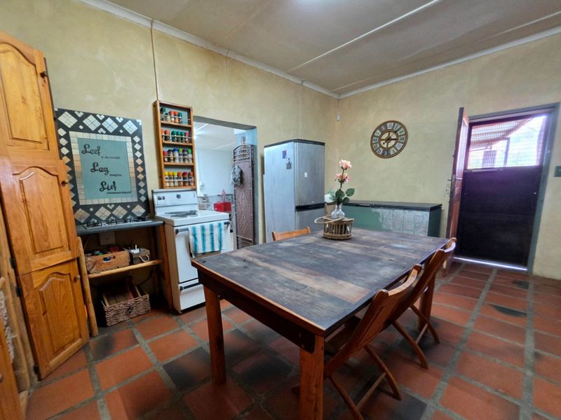 Rustic kitchen featuring terracotta floor tiles, a freestanding stove, and a stable door leading to the exterior.