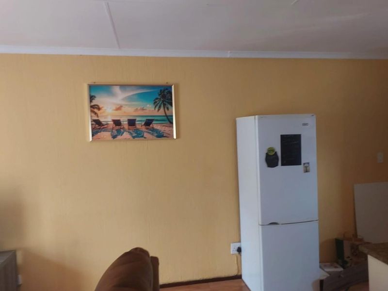 A living area featuring yellow painted walls and standard interior finishes, providing a blank canvas for potential updates and interior design improvements.