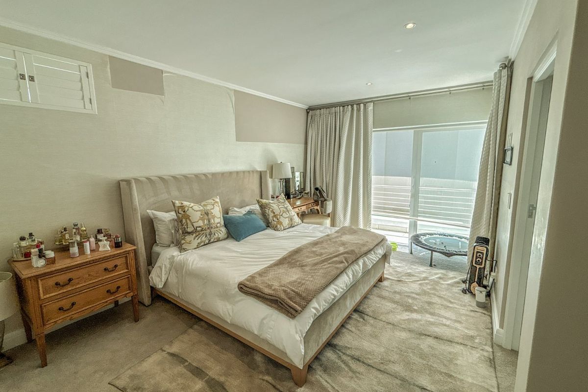 Spacious bedroom featuring neutral carpeting, recessed lighting, and a sliding glass door providing access to an outdoor area.