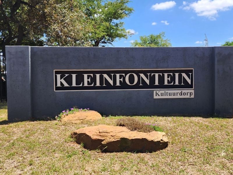 Entrance signage for Kleinfontein Kultuurdorp estate, featuring a solid boundary wall and landscaped garden area.