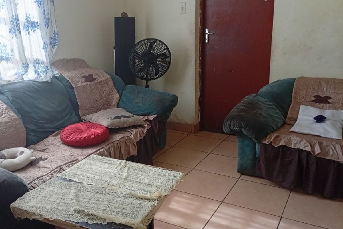 A living room area featuring tiled flooring and a standard interior door, requiring cosmetic updates to improve the overall aesthetic and condition.