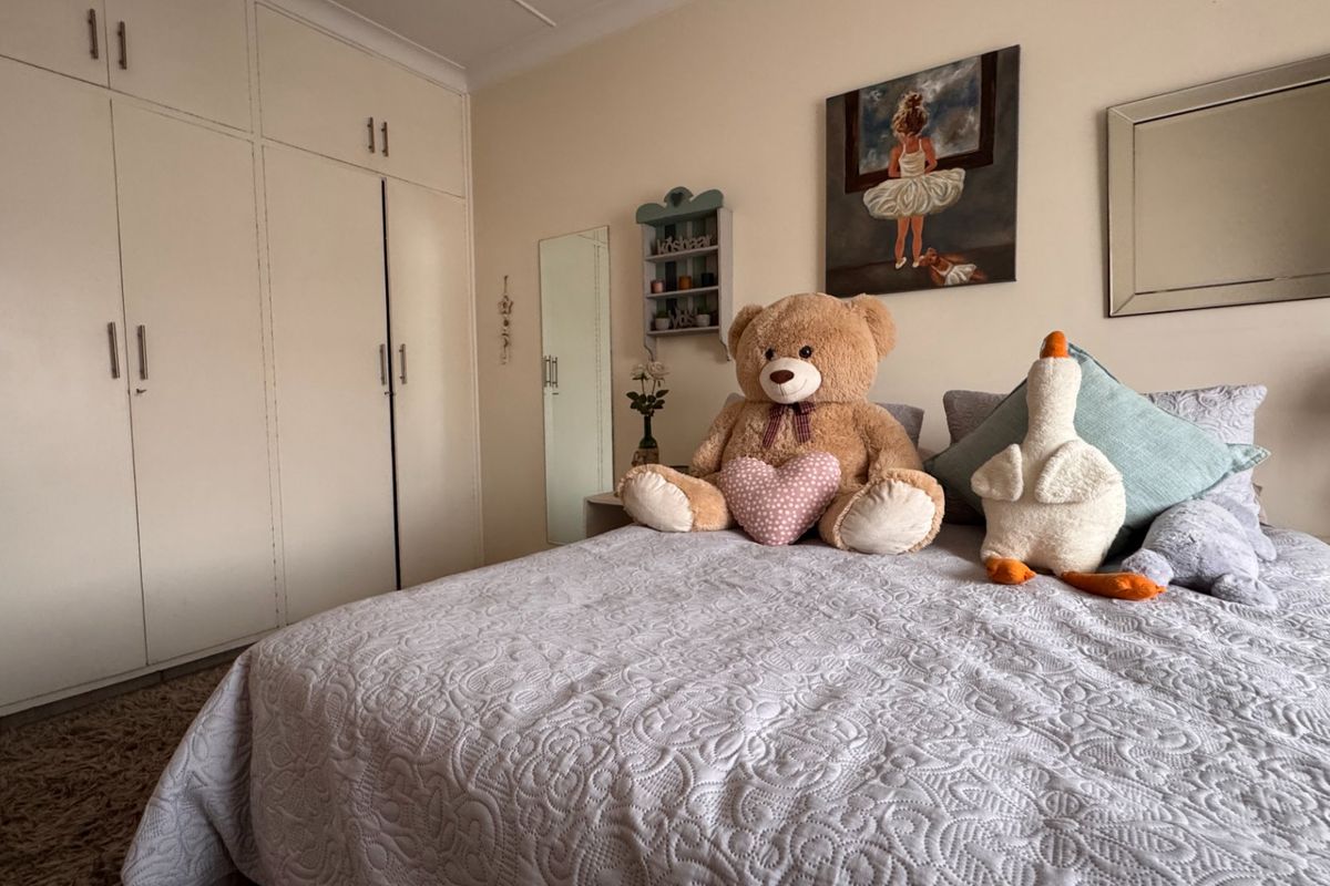 A bedroom featuring neutral walls and ample built-in cupboard storage space.