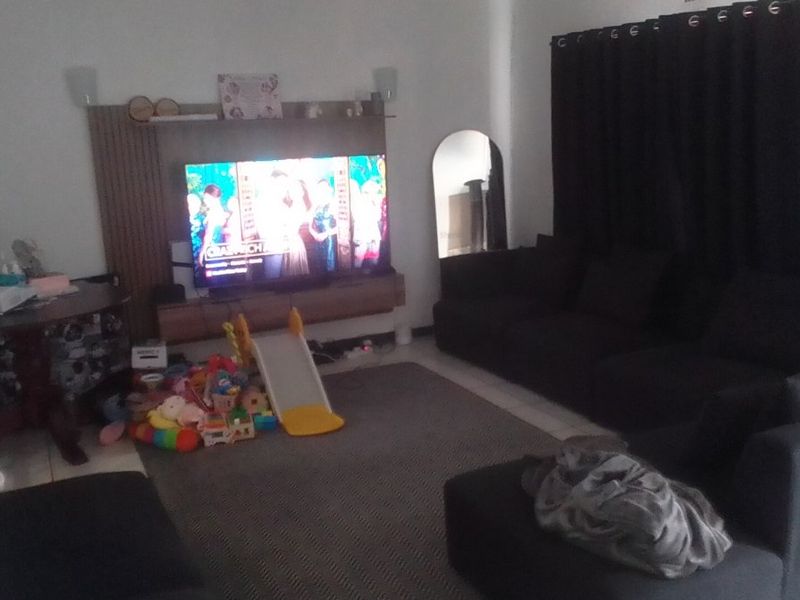 A living room featuring a built-in media unit and tiled flooring, providing a functional space for relaxation.