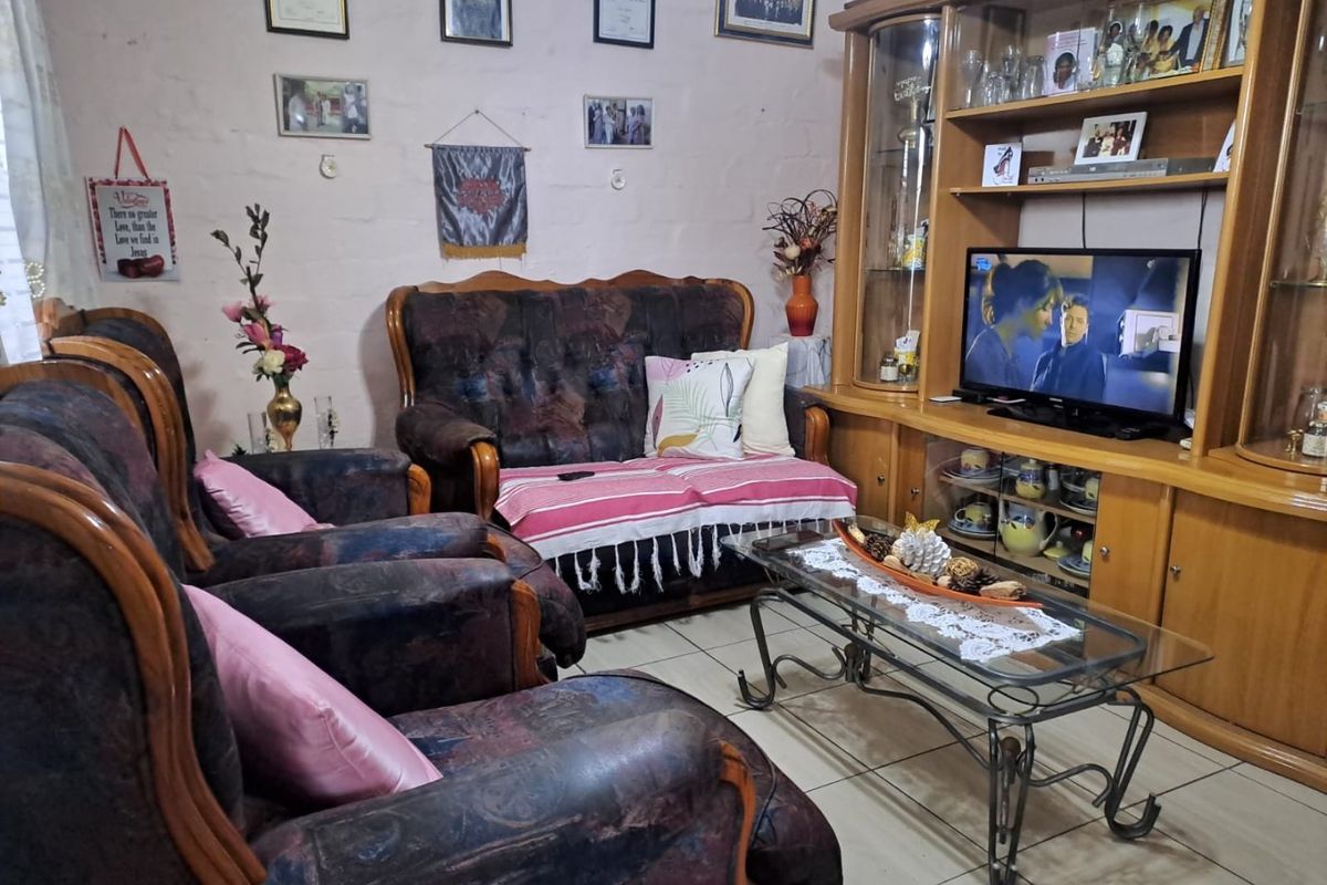 A living room featuring tiled flooring and a large built-in wooden wall unit for storage and media display.