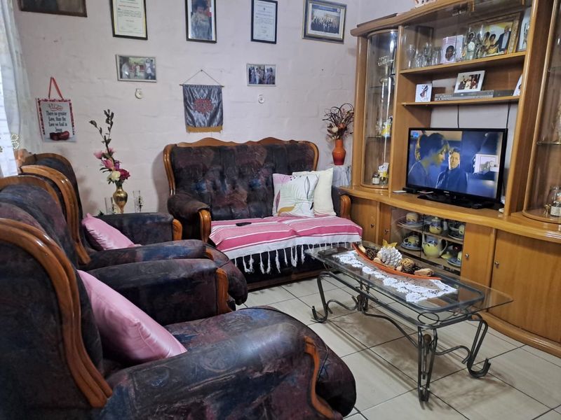 A living room featuring tiled flooring and a large built-in wooden wall unit for storage and media display.