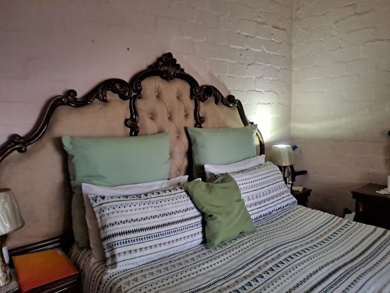 A bedroom featuring a textured exposed brick wall, providing a rustic aesthetic backdrop for the sleeping area.