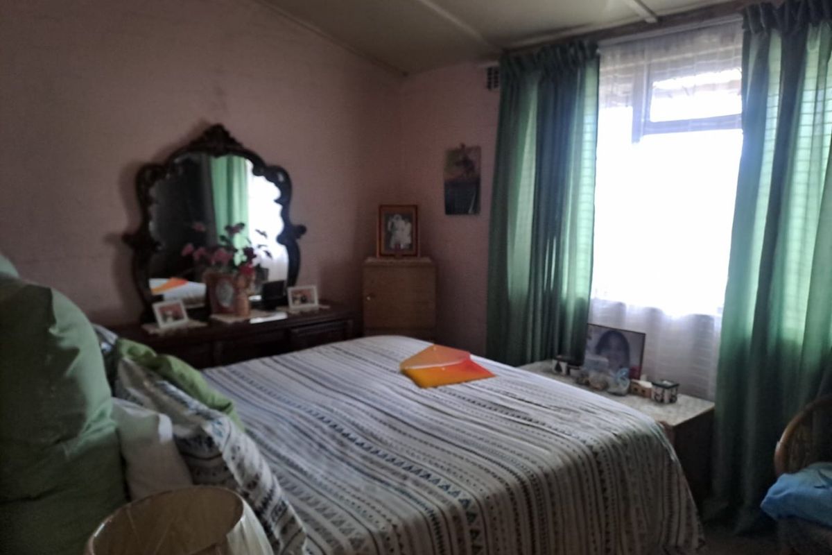 A bedroom featuring a window with curtains, providing natural light and a functional space for rest.