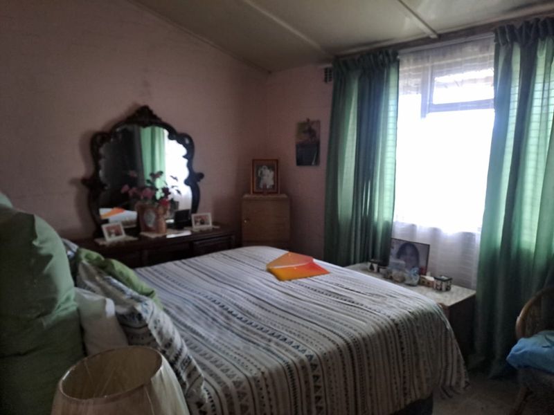 A bedroom featuring a window with curtains, providing natural light and a functional space for rest.