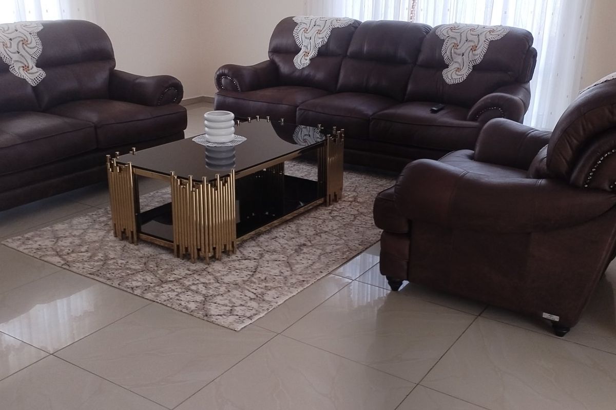 A well-maintained living room featuring polished tiled flooring and neutral wall finishes, providing a clean and functional space.