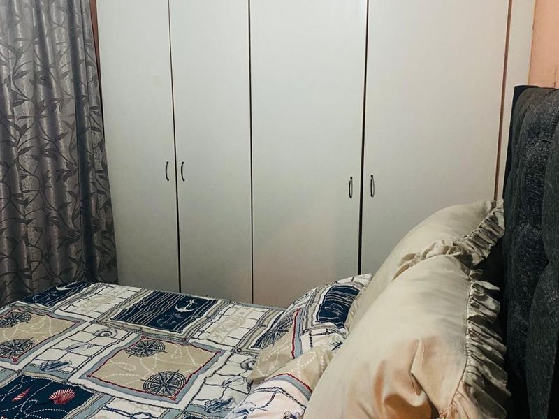 A bedroom featuring floor-to-ceiling built-in cupboards providing ample storage space.
