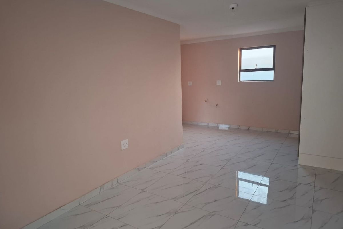 A bright, empty living area featuring modern marble-look floor tiles and neutral wall paint, providing a clean and versatile space.