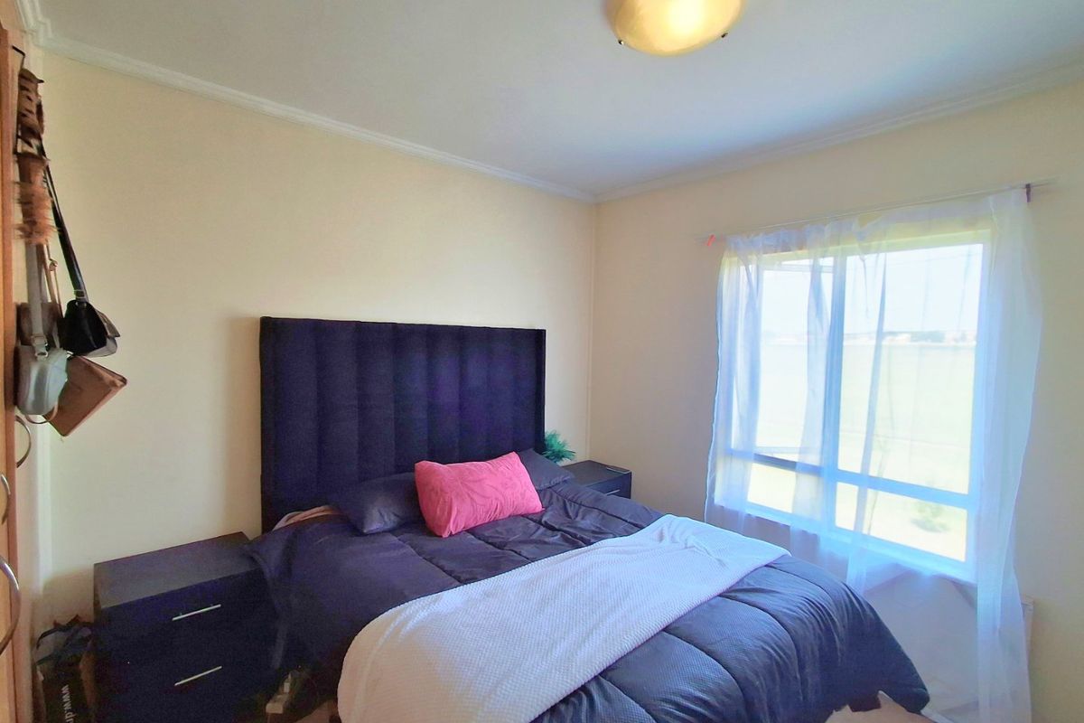 A standard bedroom featuring a large window and a central ceiling light fixture.