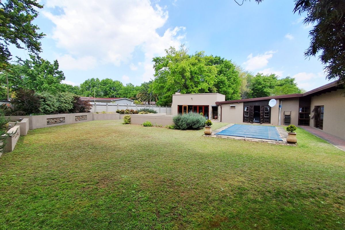 Spacious rear garden featuring a swimming pool with cover, paved patio area, and established boundary walls.
