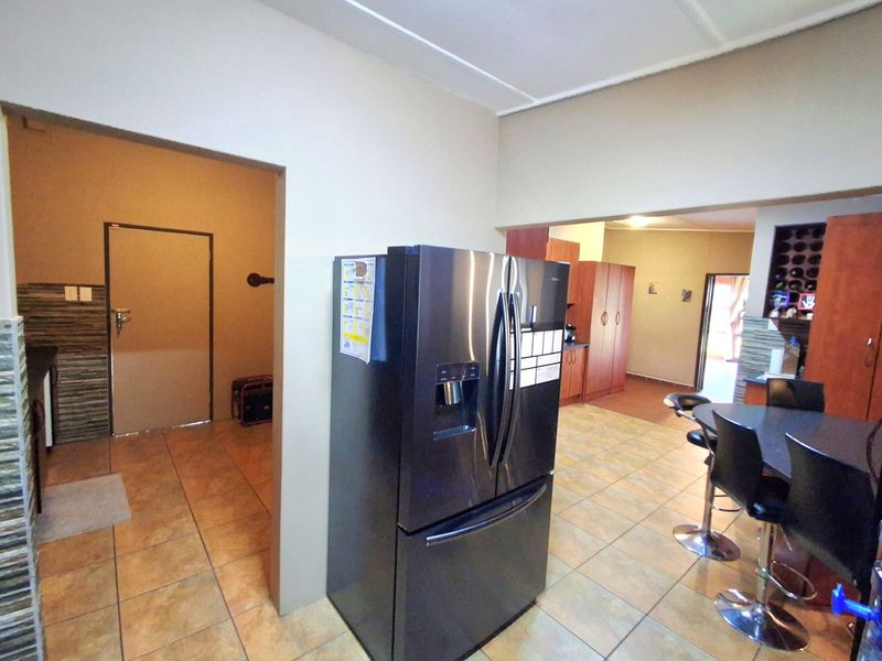 Open plan living area featuring tiled flooring, built-in cabinetry, and a dedicated wine storage section, connecting to adjacent rooms.