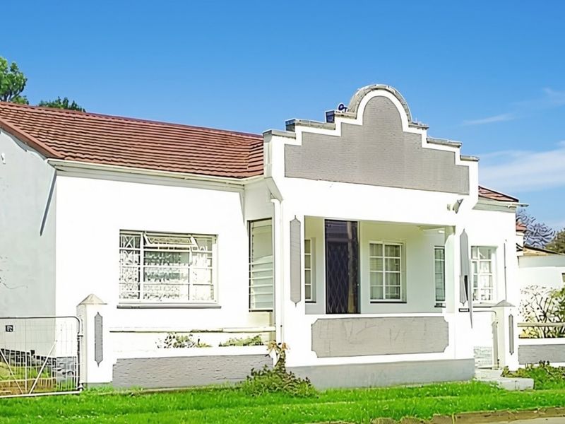 Front elevation of a single-story house featuring a covered porch, tiled roof, and perimeter fencing.