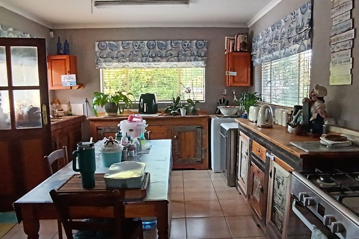 A functional kitchen featuring wooden cabinetry, a gas hob, built-in oven, and tiled flooring, offering a traditional aesthetic with ample workspace.