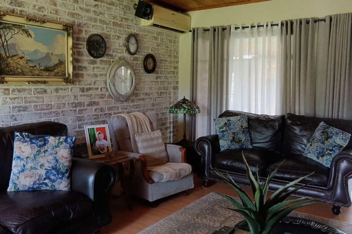 A cozy living room featuring an exposed brick feature wall, timber ceiling, and split-system air conditioning, with direct access to the outdoor area.