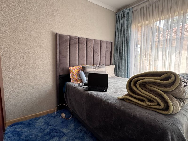 A bedroom featuring a large sliding glass door with curtain tracks and neutral wall finishes.