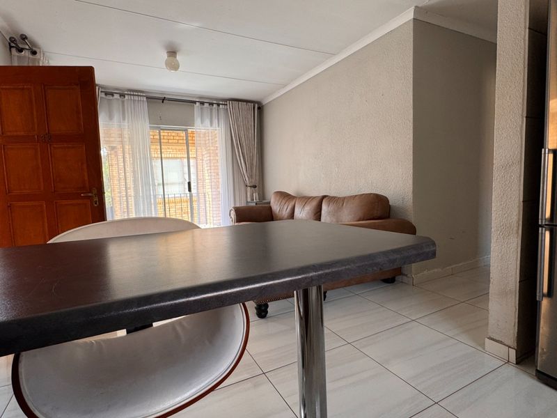 Open plan living area featuring tiled flooring and a sliding glass door providing access to the exterior.