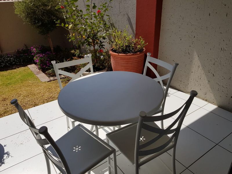 A private outdoor patio area featuring tiled flooring and direct access to a small garden space.