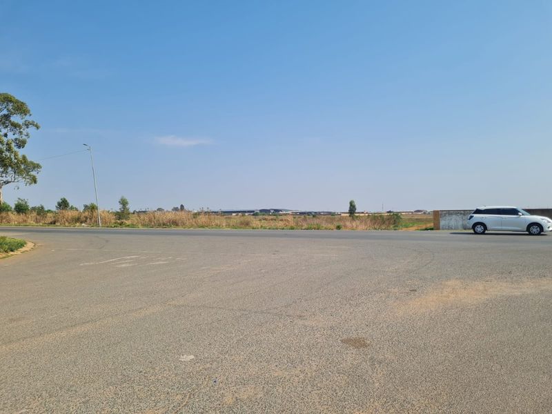 A view of the asphalt road and street frontage adjacent to the vacant residential land plot.