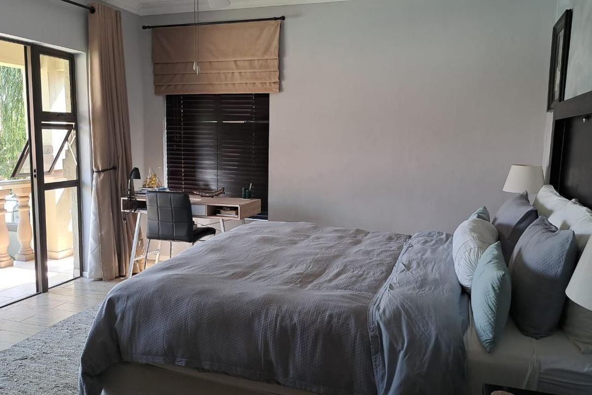Spacious bedroom featuring tiled flooring, neutral walls, and a sliding glass door providing direct access to a private balcony.