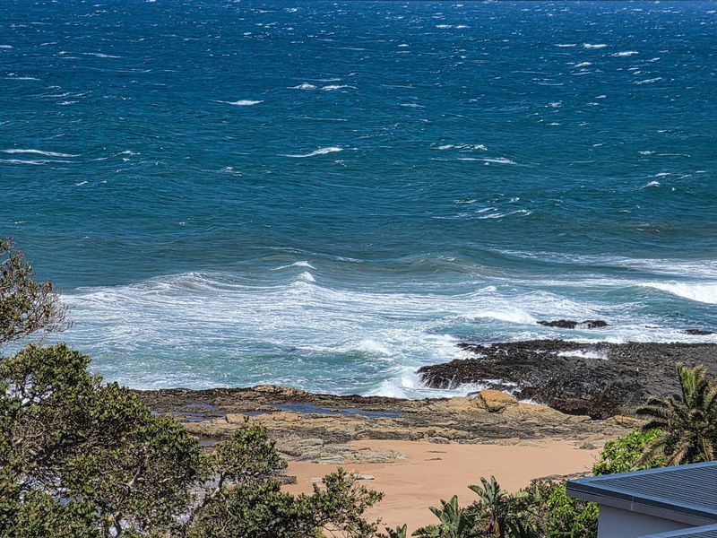 A scenic elevated view overlooking the rocky coastline and ocean waves.