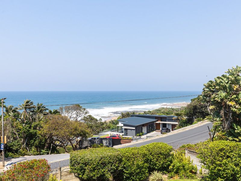 A scenic elevated view overlooking the coastline, ocean, and surrounding residential landscape.